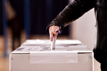 Hand casting a vote into the ballot box