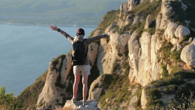 Successful woman raising hands on the top of mountain, Calanques, France