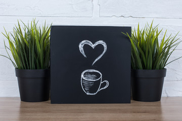 Hot coffe or tea. Draw with white chalk on blackboard. 