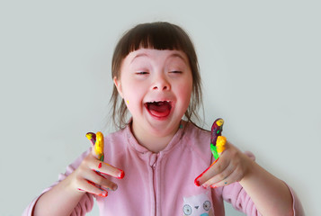 Cute little girl with painted hands. Isolated on grey background.