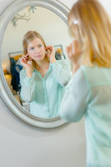Lady holding earring to her ears