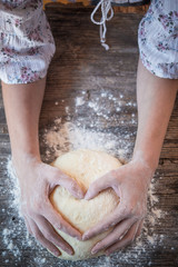 Woman holding dough heart in his hands
