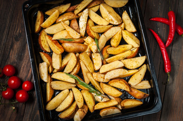 Uncooked potato wedges with rosemary and pepper