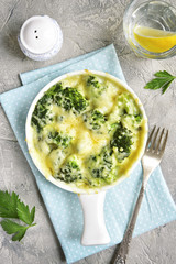 Broccoli gratin in a white baking dish .Top view.