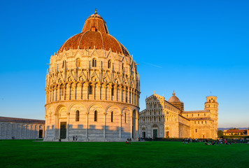 Sunset view of Baptistery of St. John (Battistero di San Giovanni di Pisa), Pisa Cathedral (Duomo di Pisa) with the Leaning Tower of Pisa (Torre di Pisa) on Piazza dei Miracoli in Pisa, Tuscany, Italy