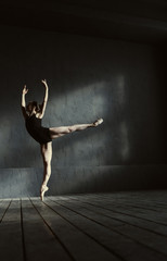 Elegant ballet dancer standing on the tiptoe in the studio