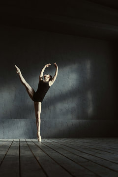 Flexible dancer standing on the tiptoe and performing the split