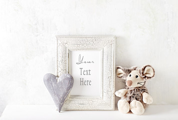 An arrangement of a mascot, wooden heart and a picture frame