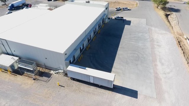Orbiting aerial shot of a warehouse with loading docks