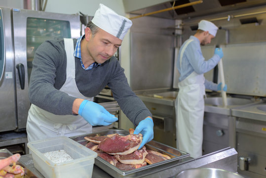 Chef seasoning cuts of meat