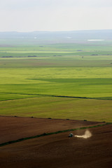 Aerial view of a tractor working a large farming area in Valladolid, Spain