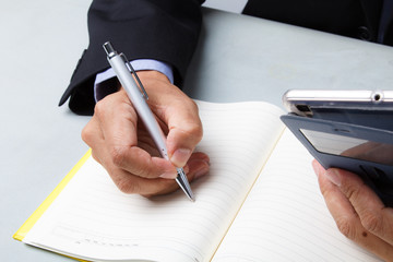 Business man writing work plan from smartphone