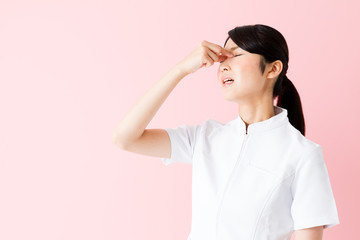 portrait of young asian nurse isolated on pink background