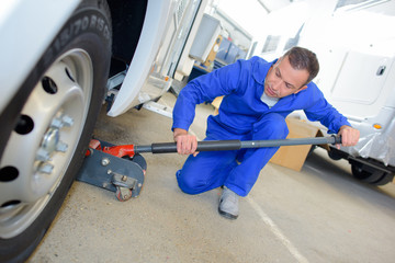 Mechanic jacking up a vehicle © auremar