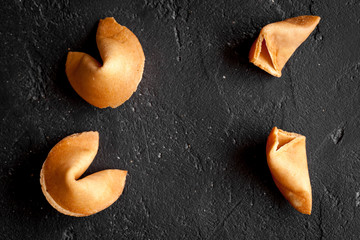 Chinese fortune cookie with prediction on dark background top view