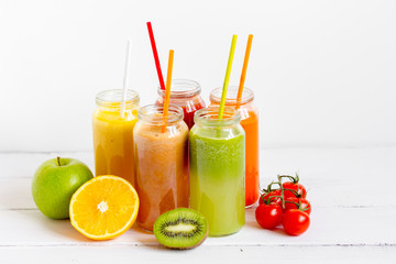 Fresh detox juices in glass bottles on white background