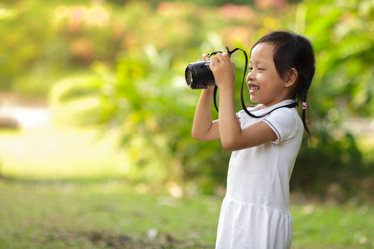 Beautiful child smiling and taking pictures at the nature field.