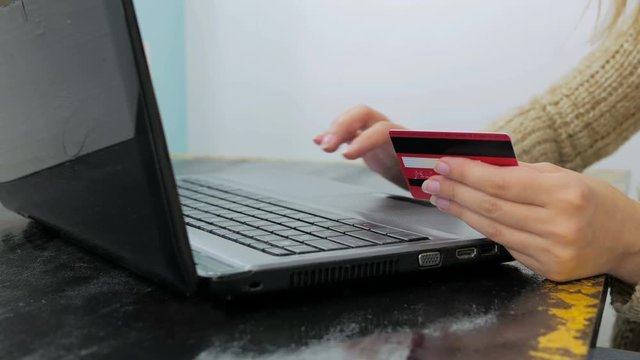 Close up shot. Young woman buying goods from the internet and entering number security code from credit card on laptop. Online, technology and internet concept.