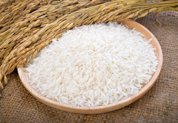 white rice on the wooden plate and rice plant