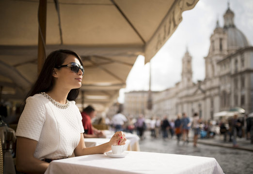 Young woman enjoying Espresso at restaurant, Piazza Navona, Rome