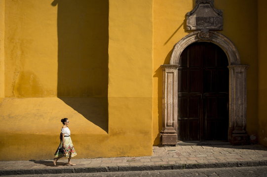 Woman walking along street, San Miguel de Allende, Guanajuato, Mexico