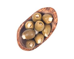 Green colossal olives hand stuffed with garlic gloves in olive wood bowl isolated on white background