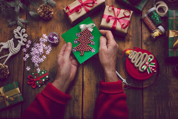 hands of senior woman making handmade New Year's or Christmas gi