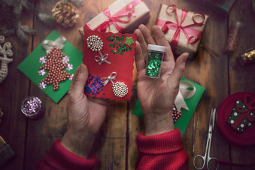 hands of senior woman making handmade New Year's or Christmas gi
