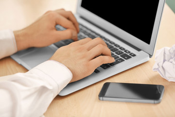 Man typing on laptop in office, closeup