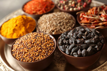 Different spices in bowls on plate