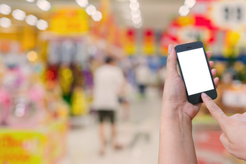 Woman hold and touch screen mobile phone while shopping in super