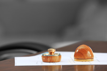 Document, wooden ink pad and stamp on notary public table