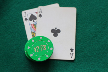 Green $25 casino chips on blackjack hand 21 green background