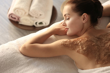 Spa concept. Young woman relaxing on massage desk with nourishing scrub on back