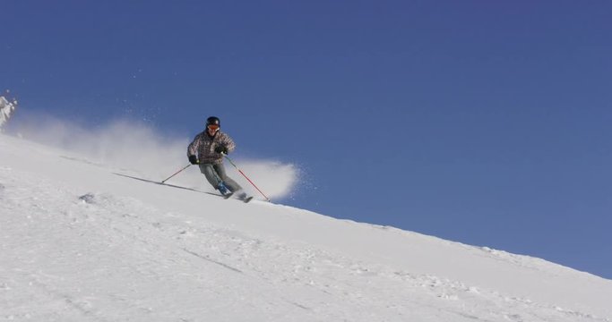 Slow Motion  Of Professional Skier Carving Near Camera With Snow Spraying  