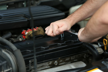 Mechanic hands repairing car in open hood