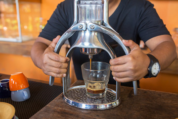 Barista makes coffee with a manual espresso maker machine