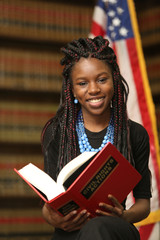 Portrait of a young attractive African American woman.  Woman lawyer in law library.