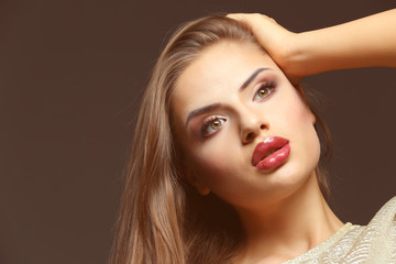 Portrait of beautiful young woman with professional makeup on dark background