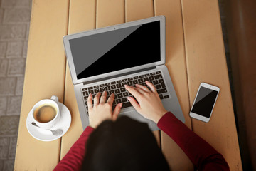 Fototapeta premium Beautiful young woman using laptop at cafe