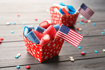 Delicious candies with USA flag in paper box on dark wooden background