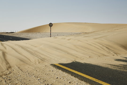 Sand dune blocks road in the Qatari desert, Qatar