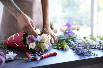 Fleuriste masculin faisant le bouquet au magasin de fleur