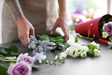 Obraz na płótnie Canvas Male florist making bouquet at flower shop
