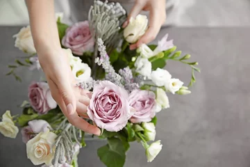 Photo sur Aluminium Fleuriste Fleuriste féminine faisant un beau bouquet au magasin de fleurs