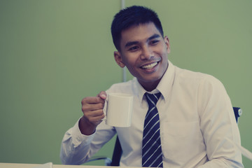 Businessman thinking about business plan and drink coffee at his office
