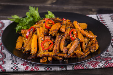 Roasted carrots in black plate, close up