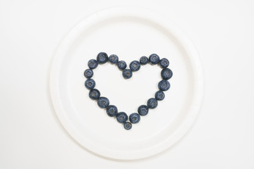 Blueberries in heart shape with white background