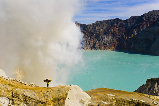 Sulphur worker appearing out of toxic fumes at Kawah Ijen, East Java, Indonesia