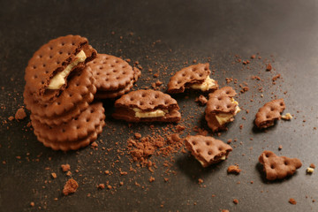 Tasty cookies with crumbs on dark background